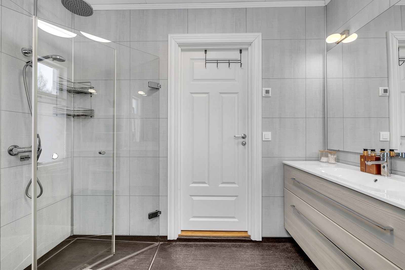 Badet rommet er pent utført med store fliser på veggene, og walk-in dusj med innfellbare glassdører og regnfallshode. Galleribilde