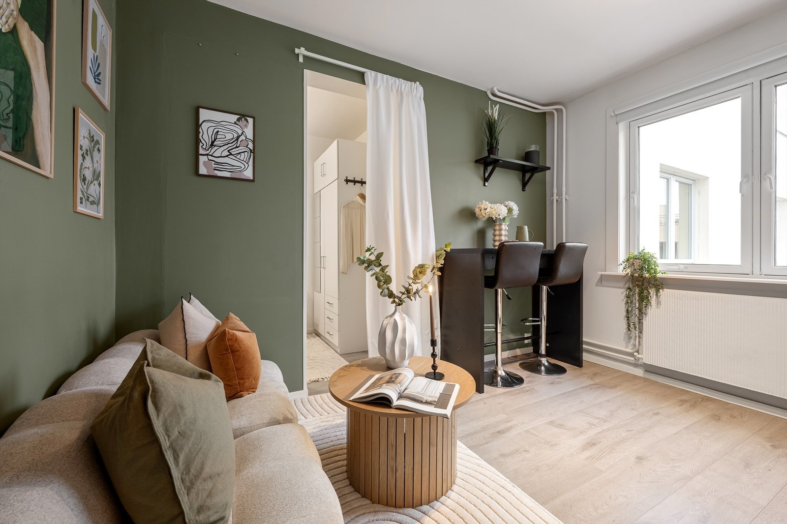 Leiligheten fremstår stilsikker med veggflater som er malt opp i en smakfull grønntone, samt elegante gulvflater bestående av moderne laminat Galleribilde