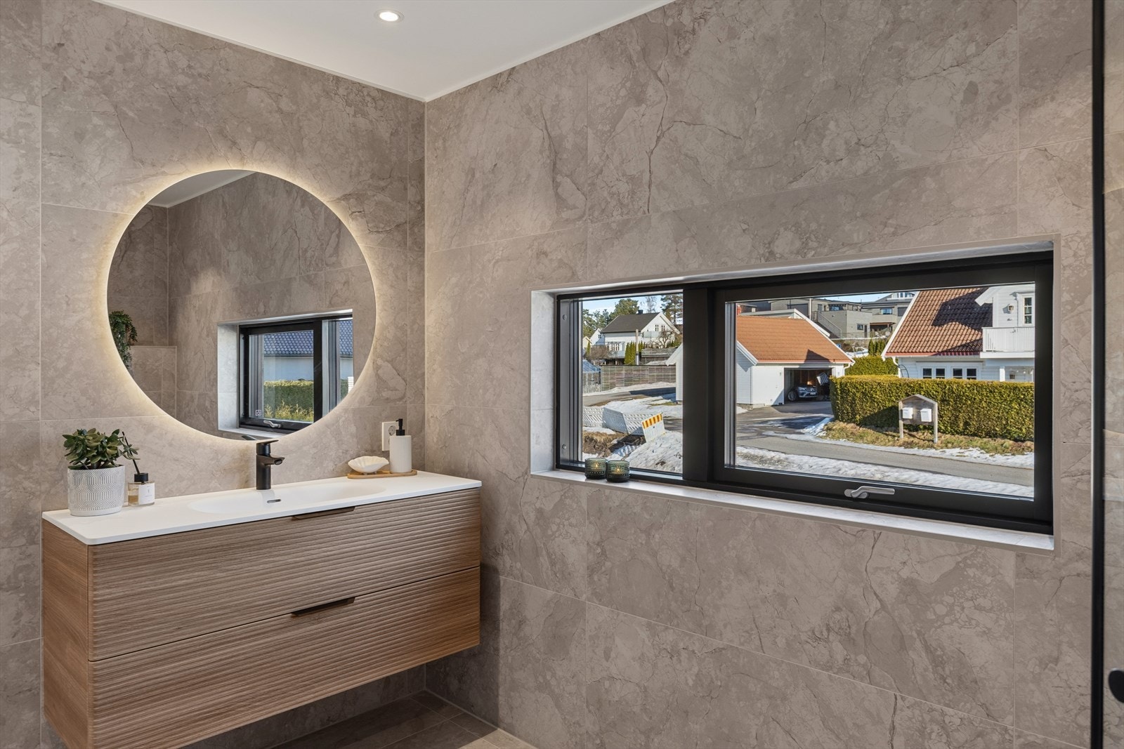 Badet i andre etasje er elegant med store, marmor-inspirerte fliser og en romslig dusjsone. Galleribilde