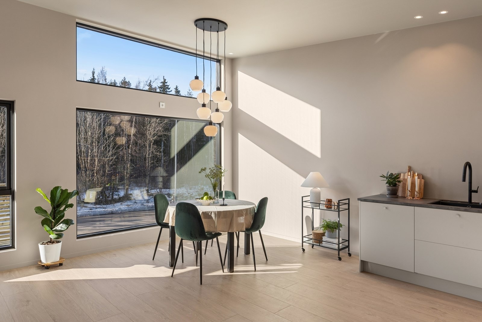 Spiseplassen er rammet inn av store vinduer med utsikt mot skogen. Galleribilde