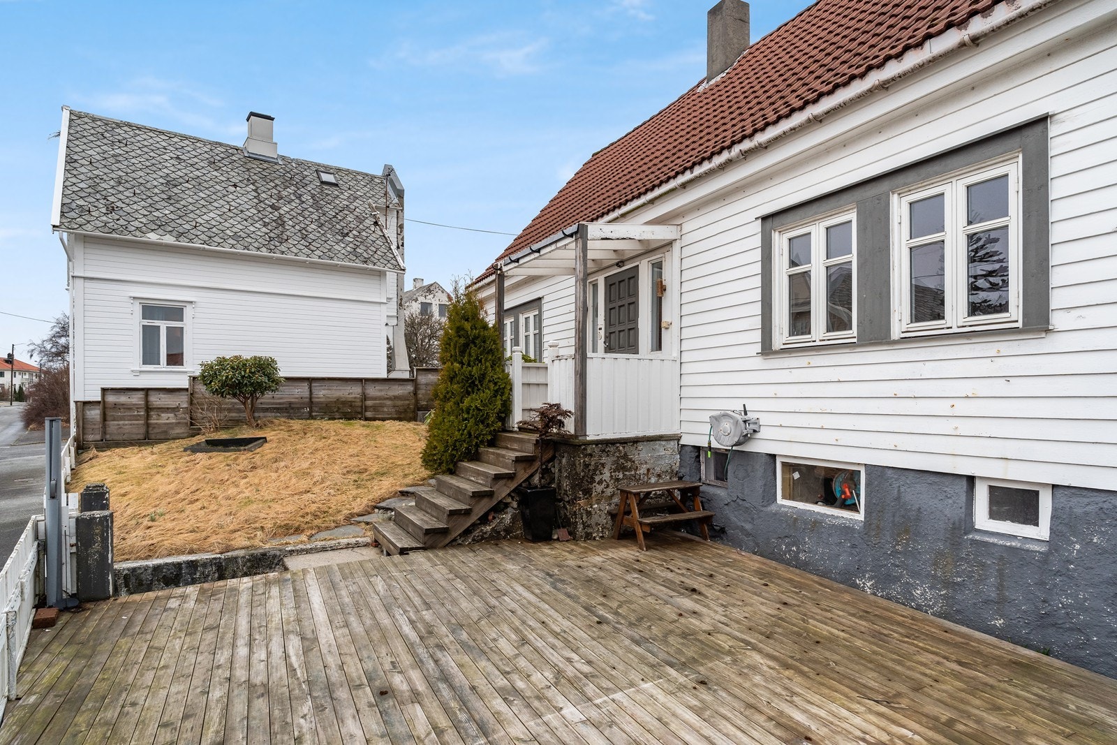Store utearealer på forsiden av huset opparbeidet med terrasse og plen. Galleribilde