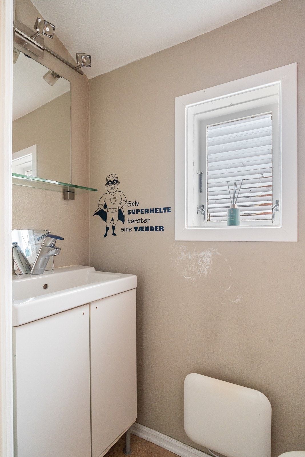 Toalettrom med servant i møblement, speil, belysning og toalett. Galleribilde