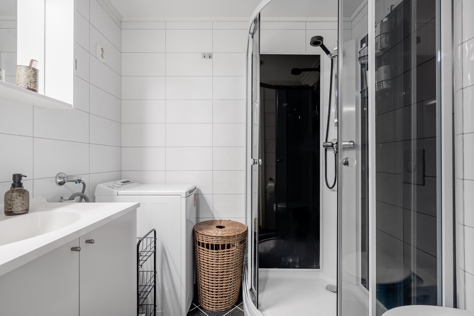Badet er innredet med dusjkabinett, wc, baderomsservant og vaskemaskin Galleribilde