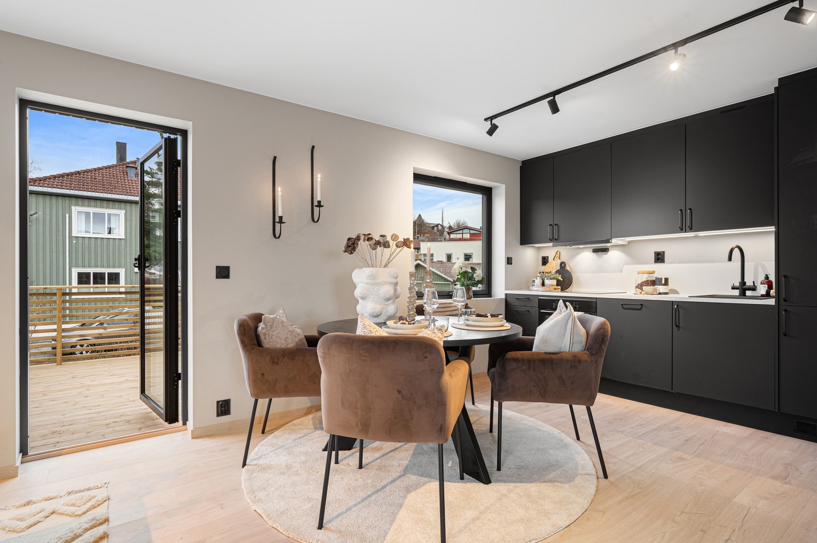 Spisebordet har sin naturlige plassering i tilknytning til kjøkkenet. Moderne spotskinne gir god belysning og står i fin stil til kjøkkenet og de øvrige sorte detaljene. Galleribilde