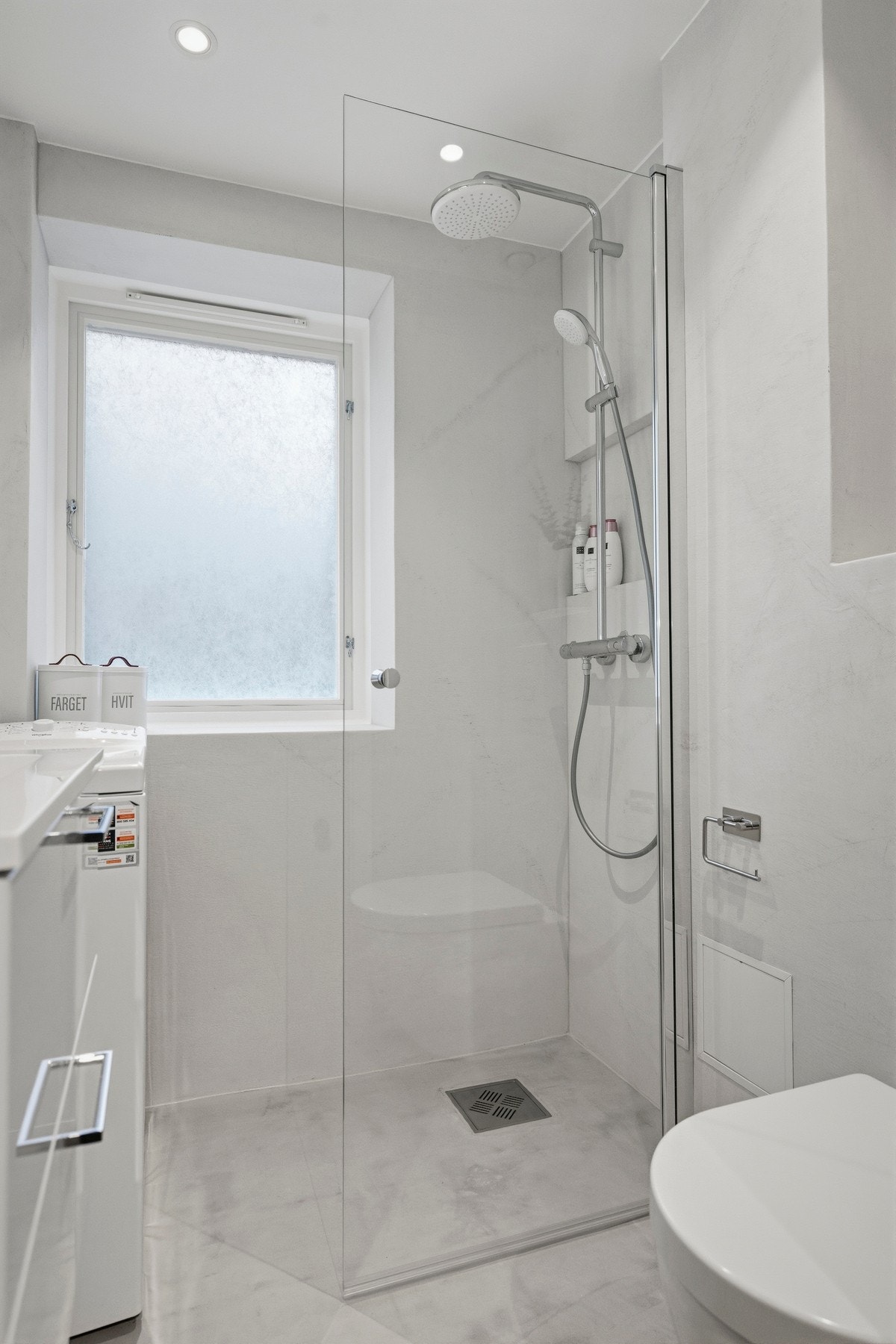 Badet har innredning med nedfelt servant, veggmontert toalett og dusjvegger/hjørne. Galleribilde