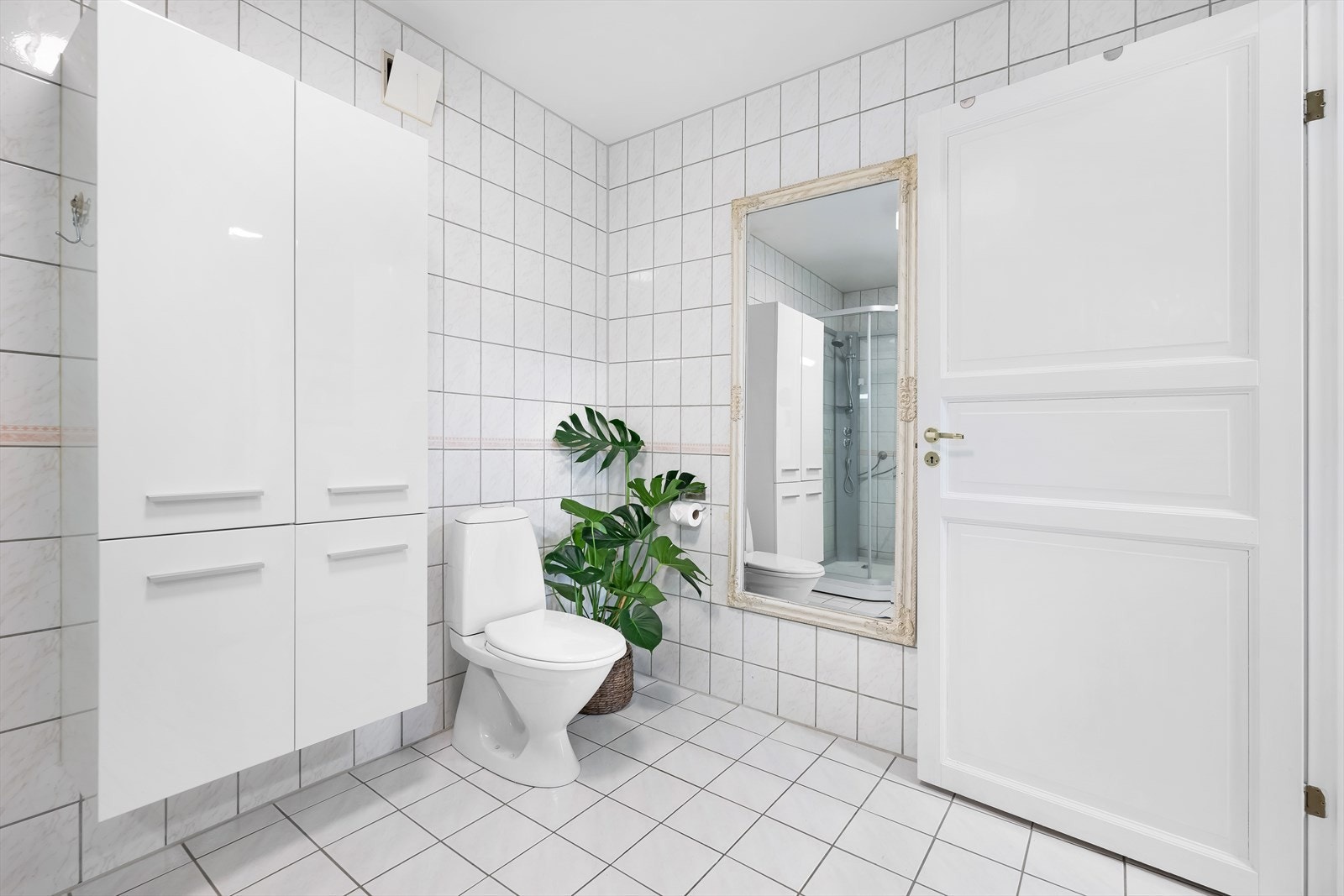 Rommet er innredet med vegghengt servant i møbel, toalett og dusjkabinett. Det er også veggskap for ekstra oppbevaring. Galleribilde