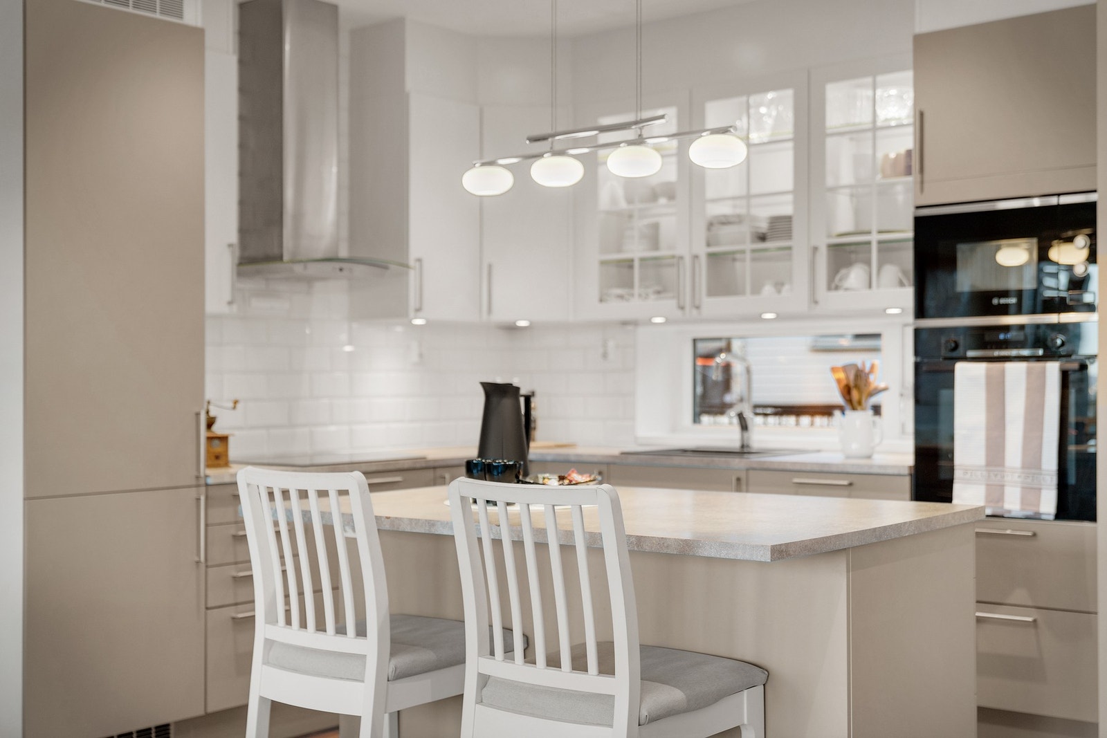 Lekker kjøkkeninnredning med integrerte hvitevarer og kjøkkenøy Galleribilde