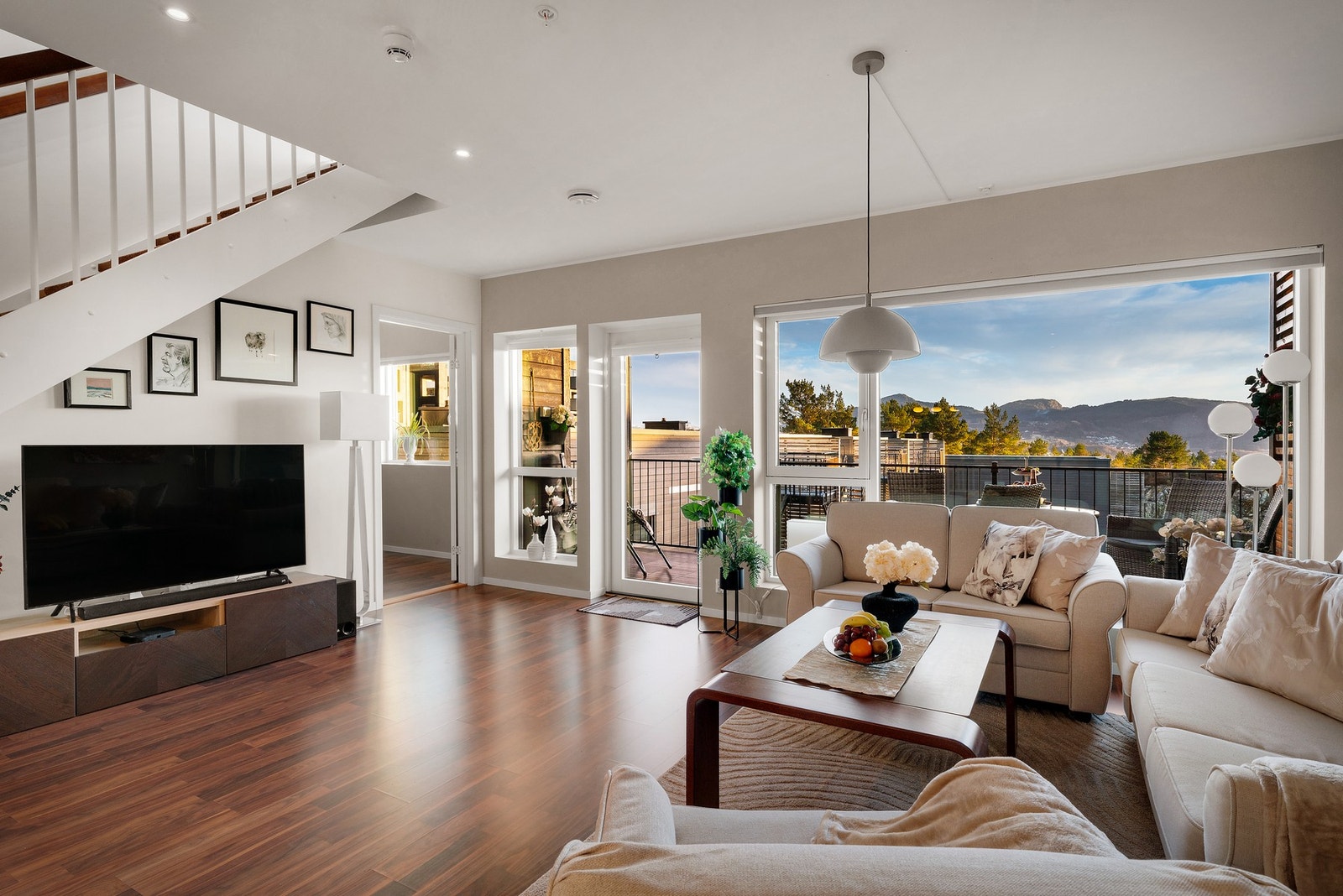 Fra kjøkkenet har man god kontakt med de som oppholder seg i stuen. Store vindusflater i front sikrer både utsikt og godt med dagslys. Galleribilde