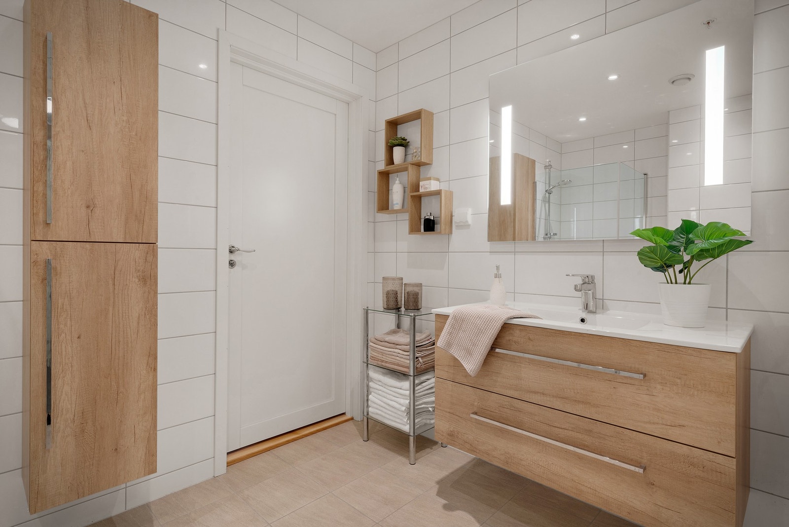 Badet er godt utstyrt med bl.a. håndvask med underskap, speilbelysning over vask, dreibare dusjvegger samt vegghengt skap og wc Galleribilde