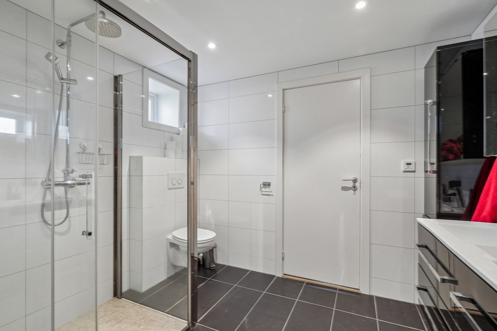 Vegghengt toalett og dobbel dusj med skyvedører i glass. Galleribilde