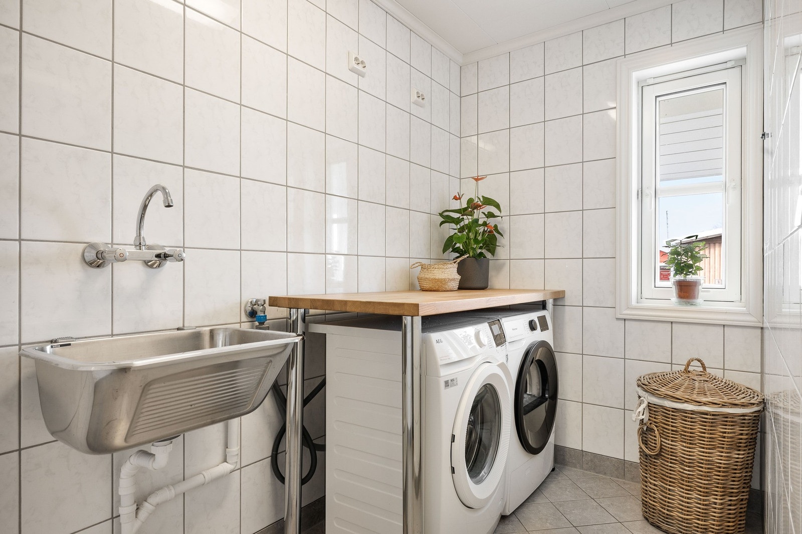 Flislagt vaskerom med vaskerom, opplegg for vaskemaskin og tørketrommel Galleribilde