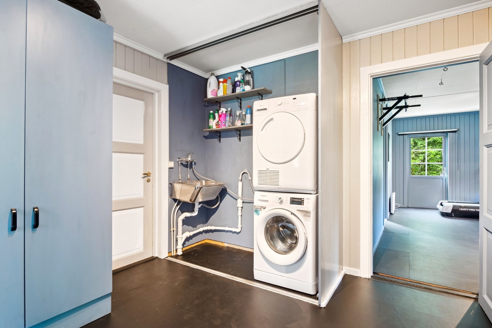 Praktisk vaskerom med utslagsvask og opplegg for vaskemaskin. Rommet er av ukjent standard og opprinnelse, og avviker fra dagens våtromskrav, så rehabilitering må påregnes. Galleribilde