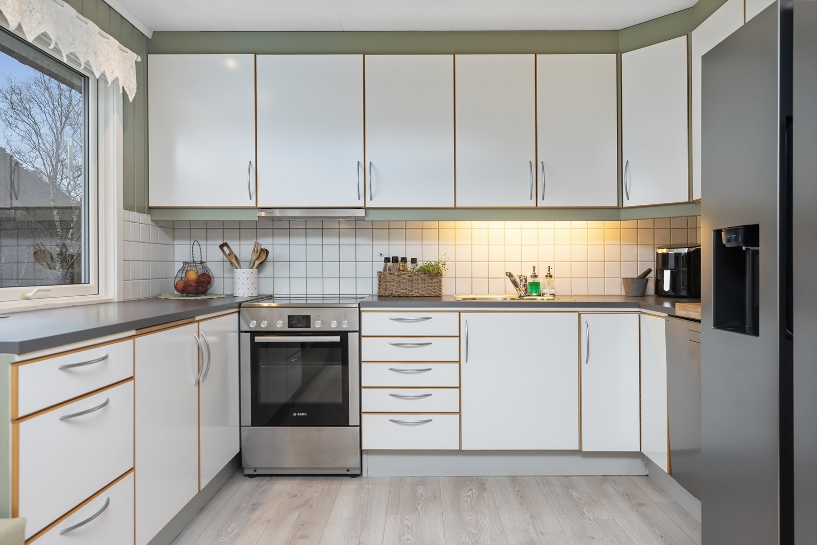 Kjøkkenet har innredning med glatte fronter og benkeplaten er av laminat Galleribilde