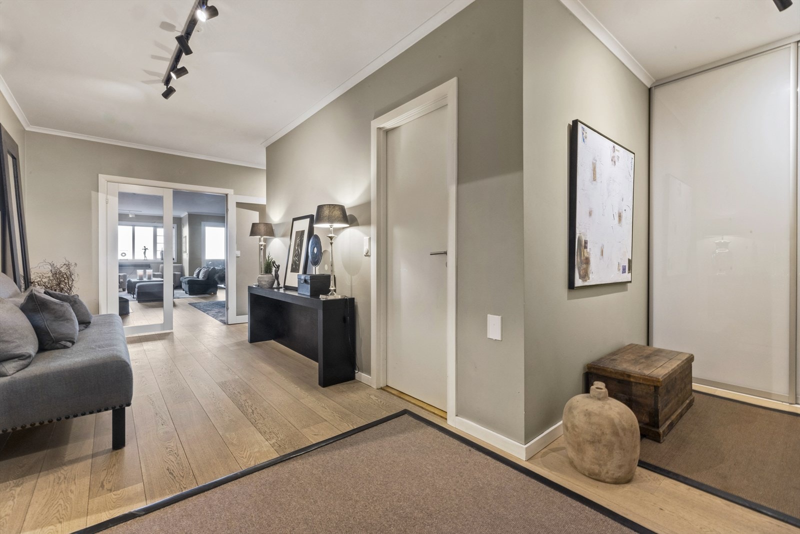 Innbydende og romslig entré/hall med skyvedørsgarderobe Galleribilde