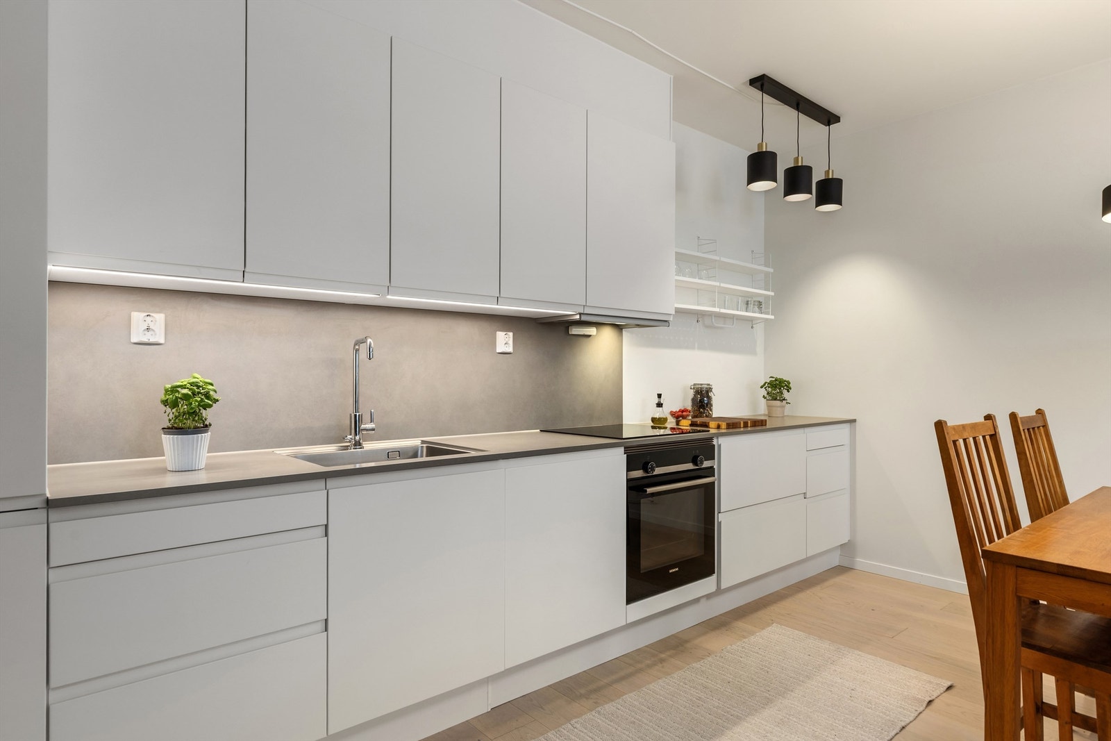 Kjøkkenet er stilrent og moderne med god skap- og benkeplass. Galleribilde