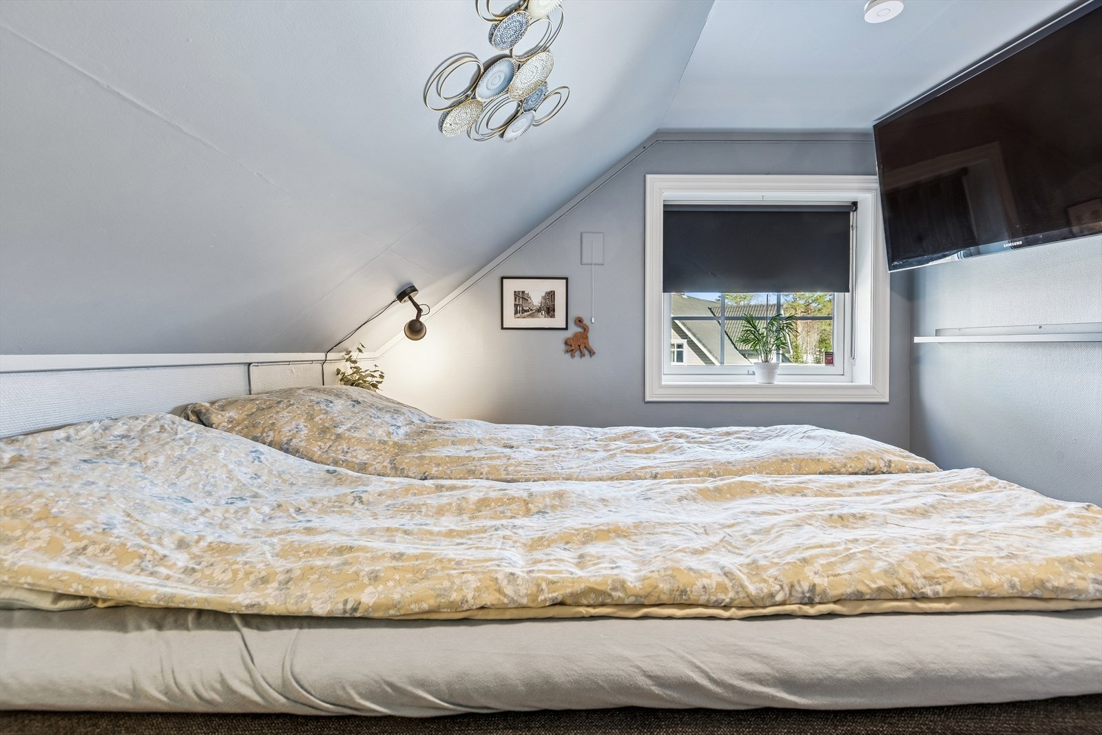 Skråtaket gir en lun og koselig atmosfære på soverommet. Galleribilde