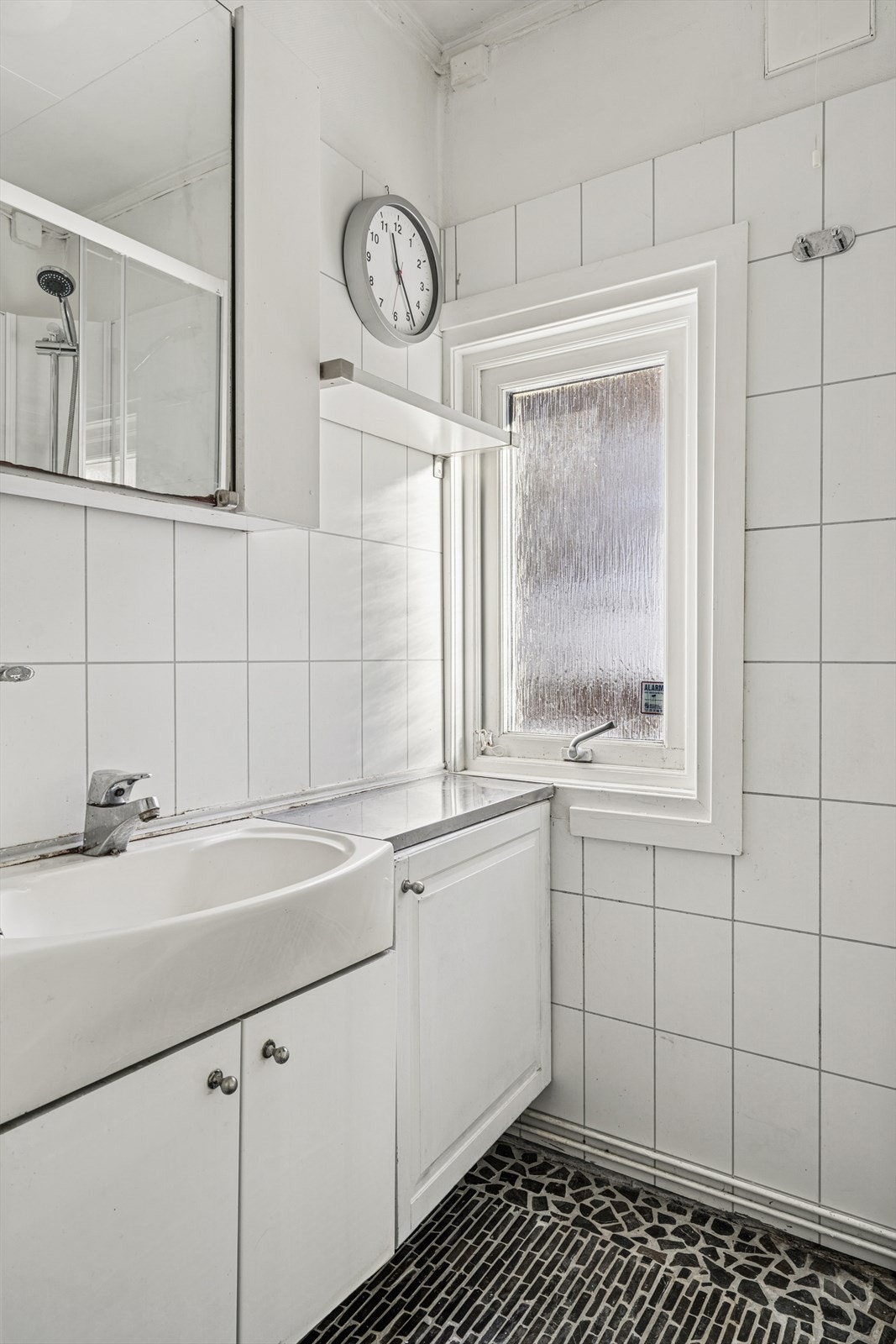 Badet er innredet med baderomsinnredning med heldekkende utslagsvask og speilskap over, gulvmontert toalett samt et nyere dusjkabinett. Galleribilde