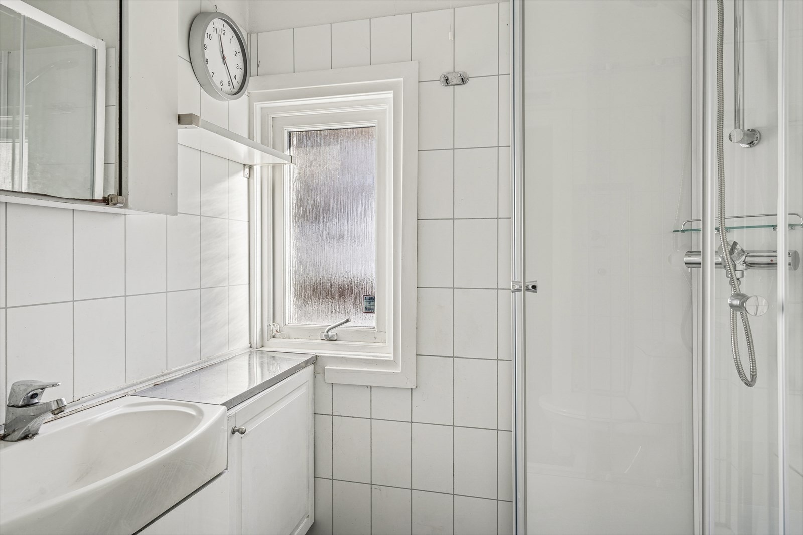 Rommet har veggventil med naturlig lufting, og en stråleovn er montert over døren for oppvarming. Gulvet er belagt med steinfliser, mens veggene har baderomsplater. Galleribilde