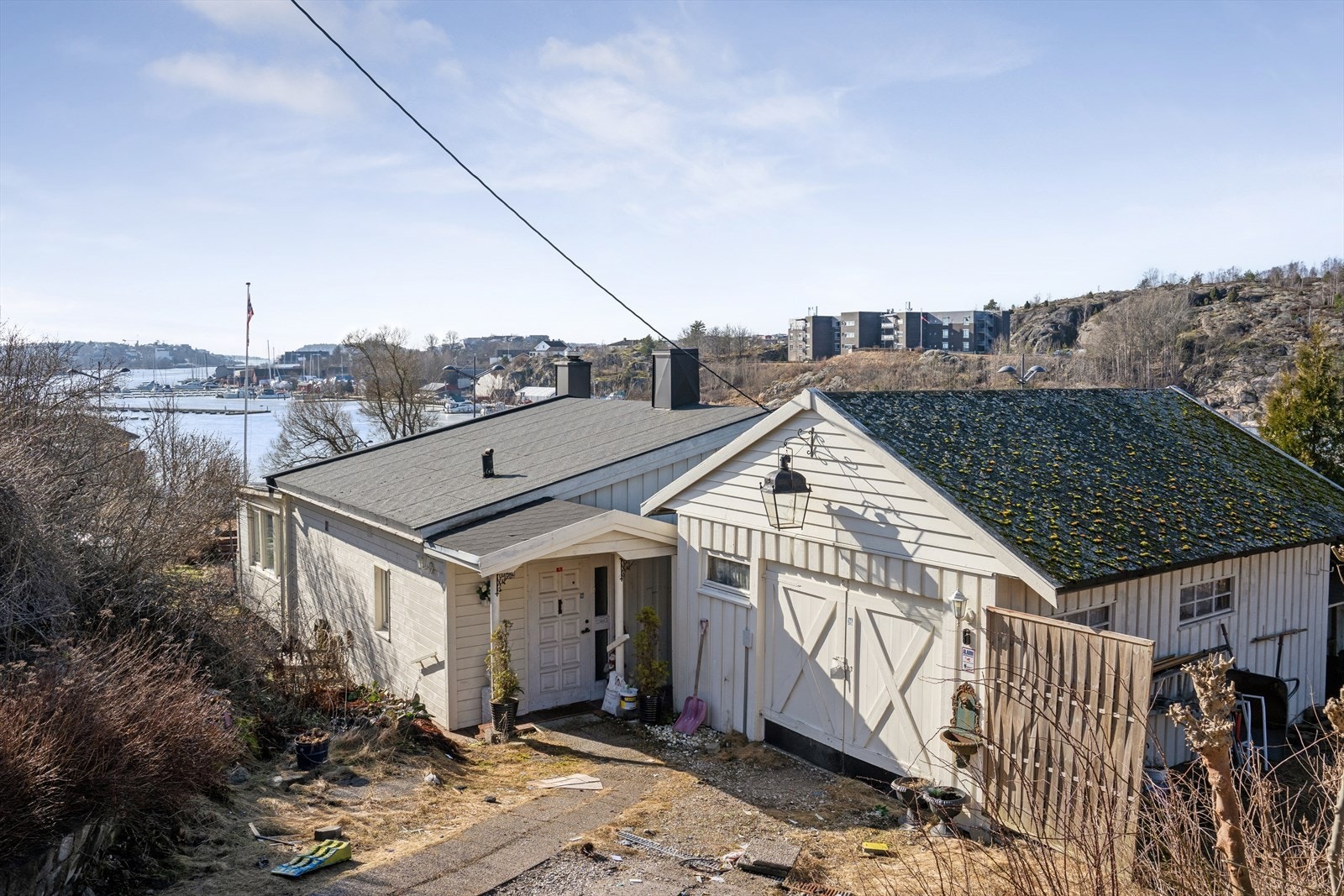 Eiendommen har en gruset gårdsplass som fører til et overbygd inngangsparti og garasjen. Galleribilde