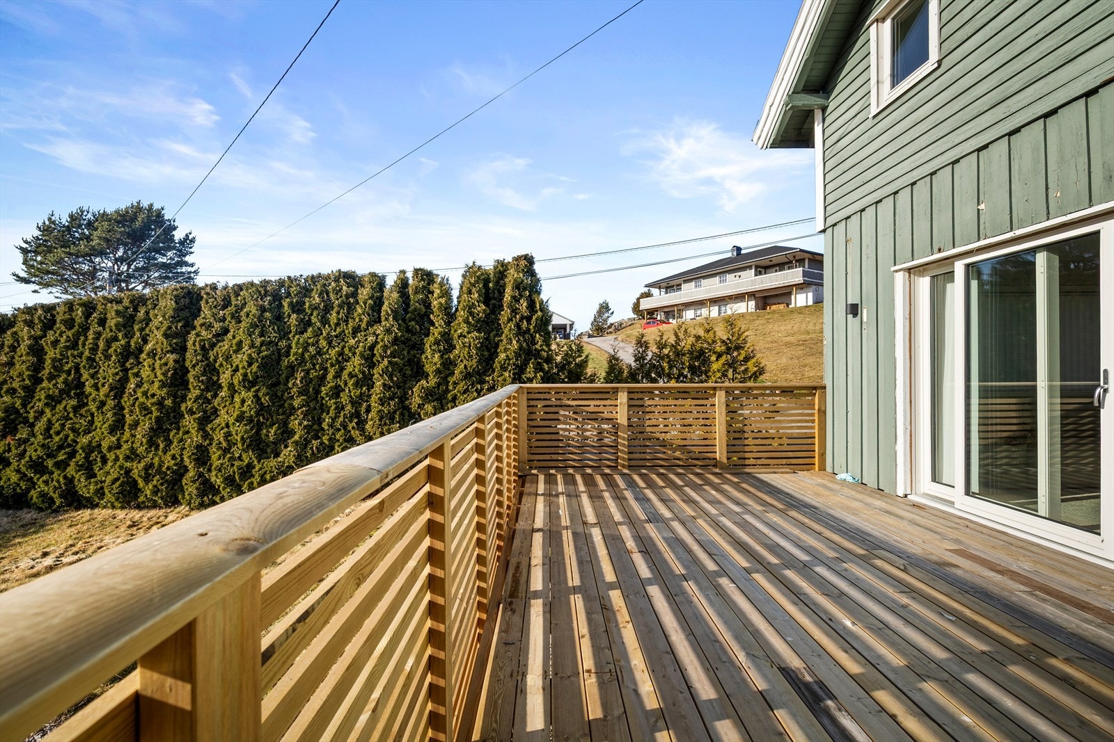 Hekken rundt eiendommen sørger for at man kan sitte delvis skjermet på terrassen. Galleribilde