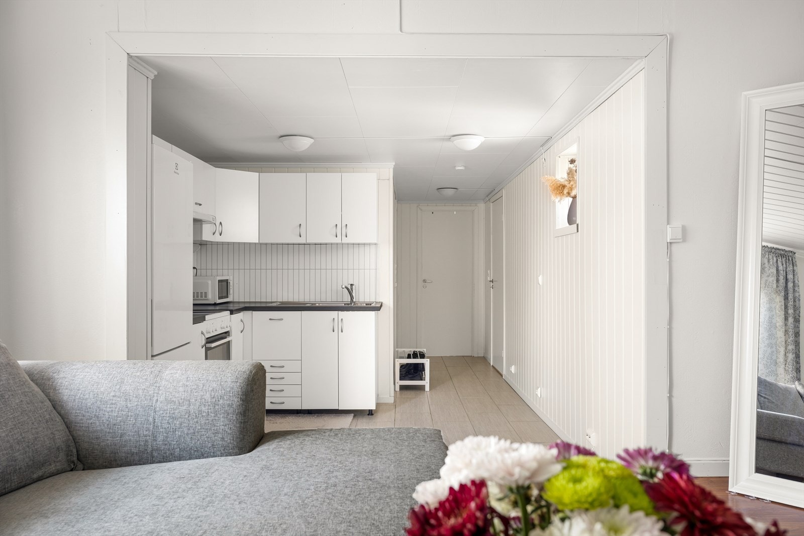 IKEA kjøkken med laminert benkeplate og oppvaskkum. Det er montert sprutsikker plater mellom benk og overskap, praktisk ved matlaging. Galleribilde