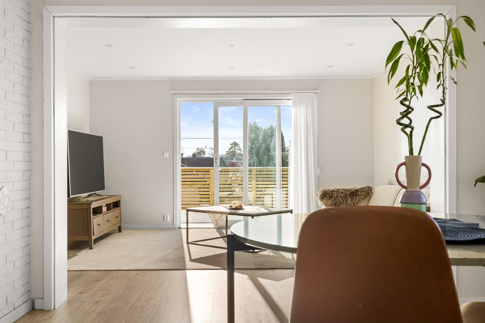 Store vindusflater lyser opp stuen med naturlig sollys. Galleribilde