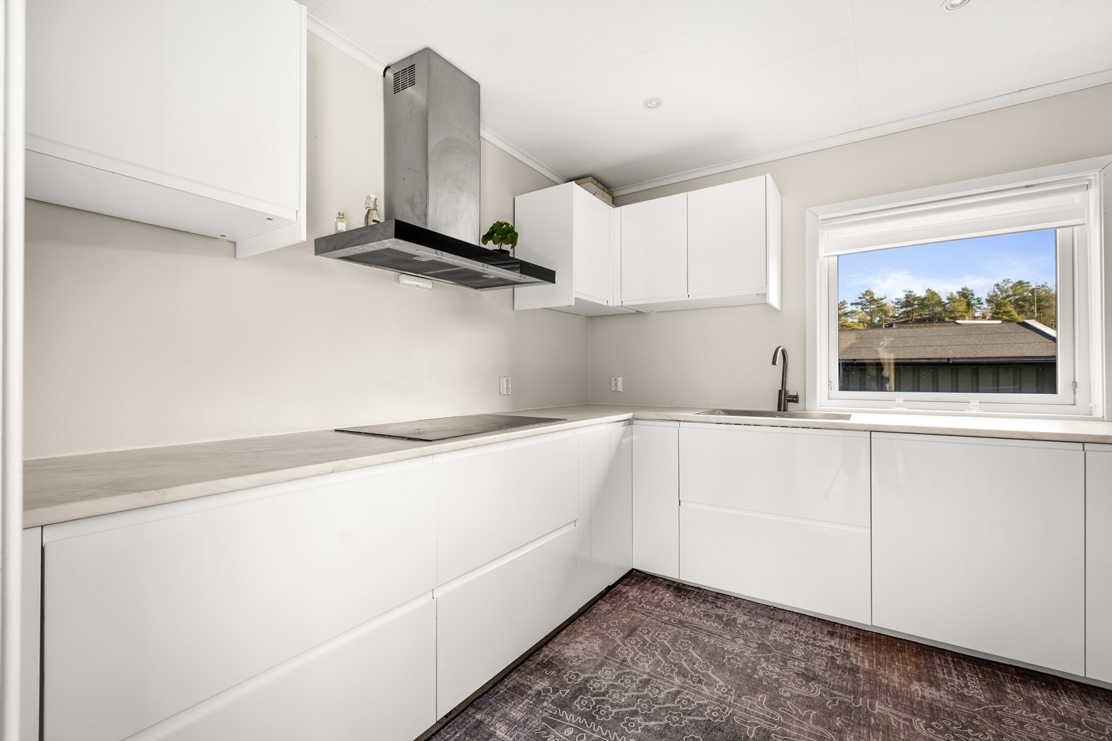 Stilfullt IKEA kjøkken med hvite slette fronter, laminert benkeplate og oppvaskkum. Galleribilde