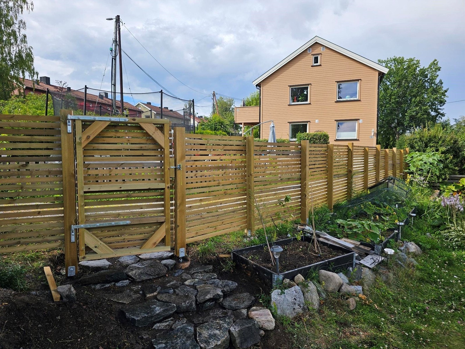 Disp. hage er pent opparbeidet med gjerde, bedd, plantekasser og busker. Galleribilde
