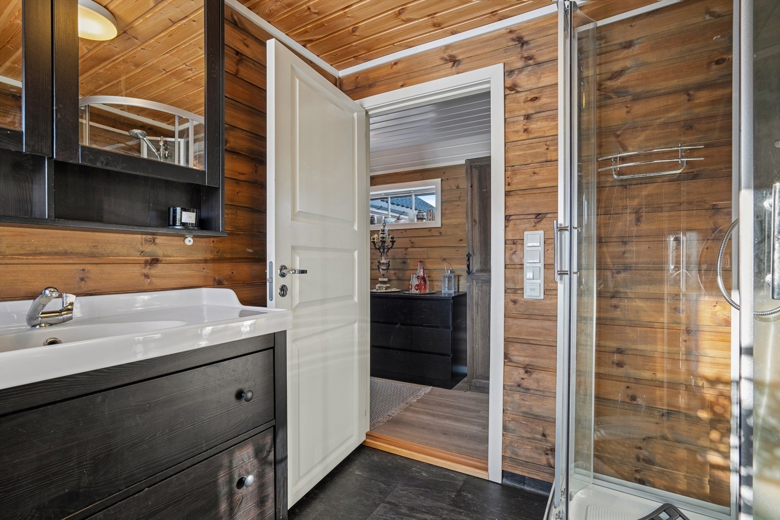 Badet er utført med vinyl på gulv med varmekabler under og panel på vegger - Rommet er ikke bygget som våtrom og har ikke sluk Galleribilde