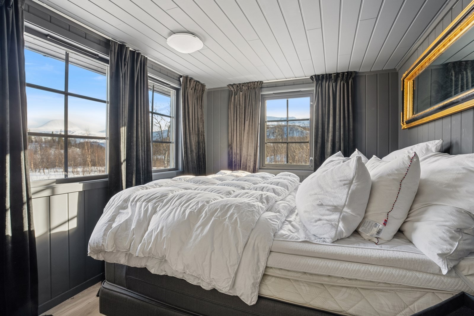 Soverom I - Hovedsoverommet er malt i en dempet fargetone og har store vinduer med flott utsikt Galleribilde