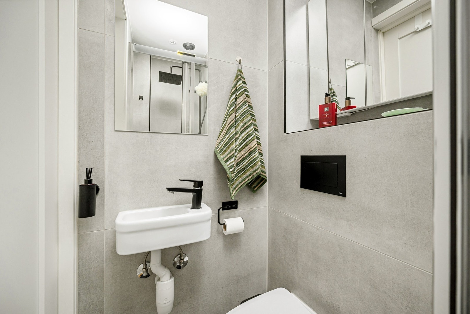 Badet har vegghent WC, dusj og servant med speil. Galleribilde