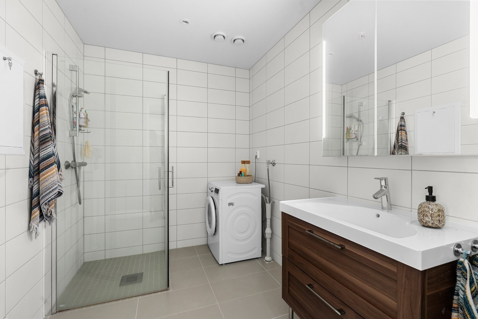 Pent og flislagt bad på 5,5 m² med behagelig gulvvarme som varmekilde. Galleribilde