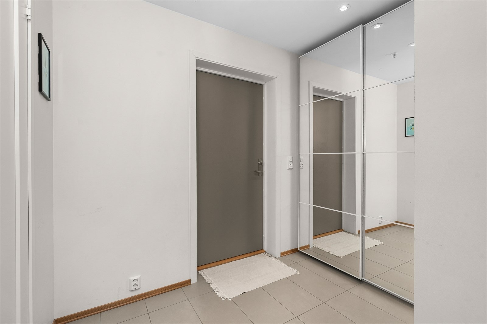 Romslig entré med garderobeløsning og flislagt gulv med gulvvarme. Galleribilde