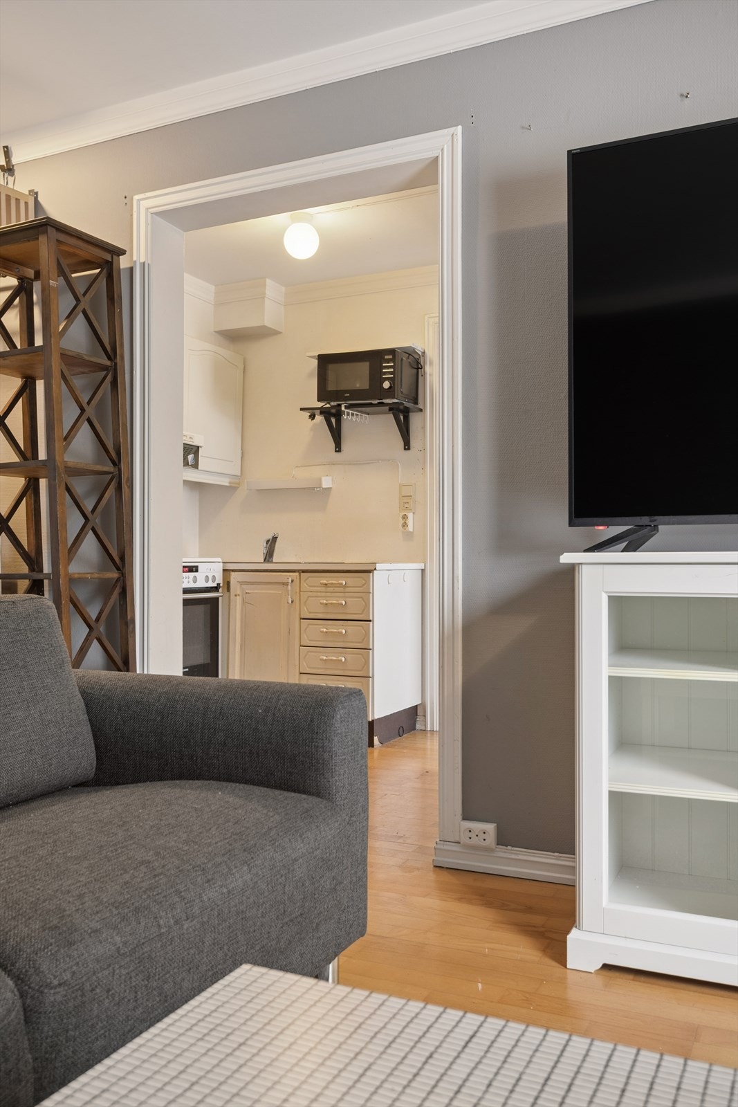 Kjøkkenet er plassert i en delvis adskilt løsning fra stuen, noe som gir en naturlig soneinndeling mellom rommene. Galleribilde