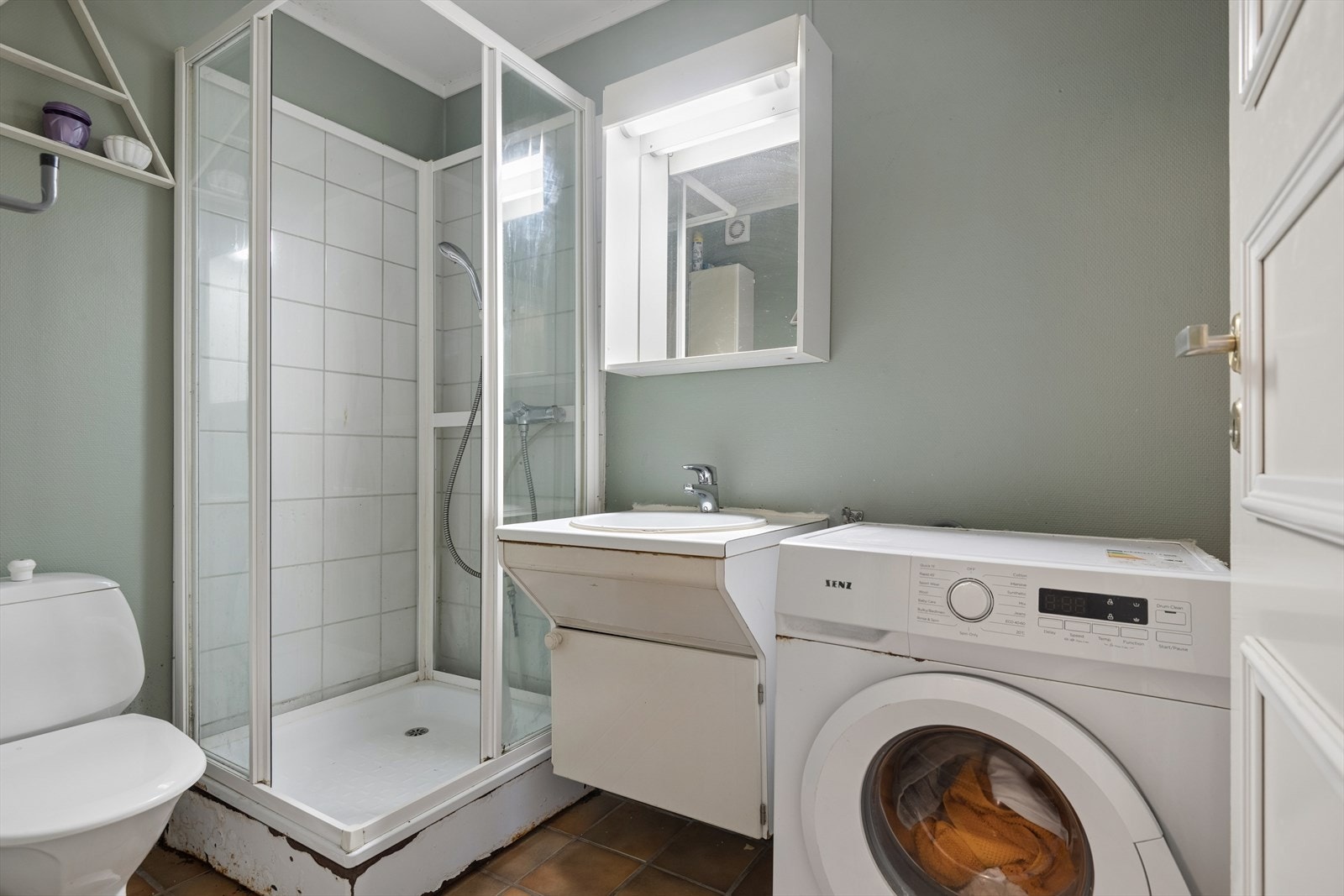 Badet har flislagt gulv med varmekabler, samt vegger med en kombinasjon av fliser og tapet. Galleribilde