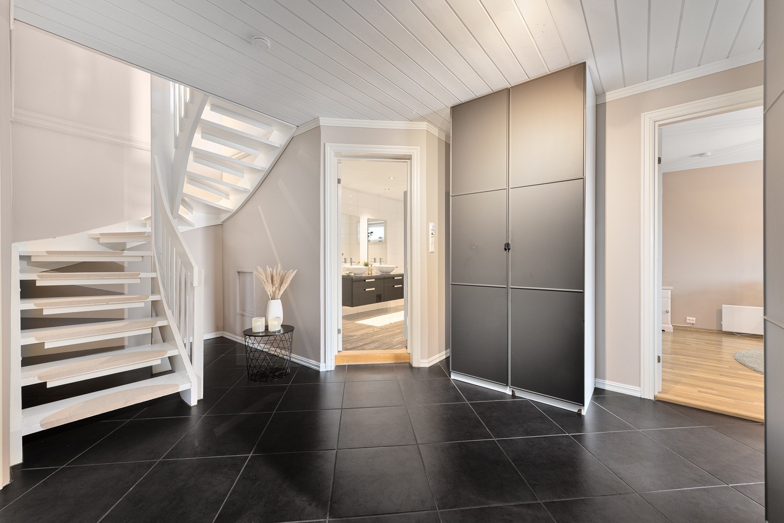 Hallen i underetasjen har flislagt gulv og en pen tretrapp som binder etasjene sammen. Galleribilde