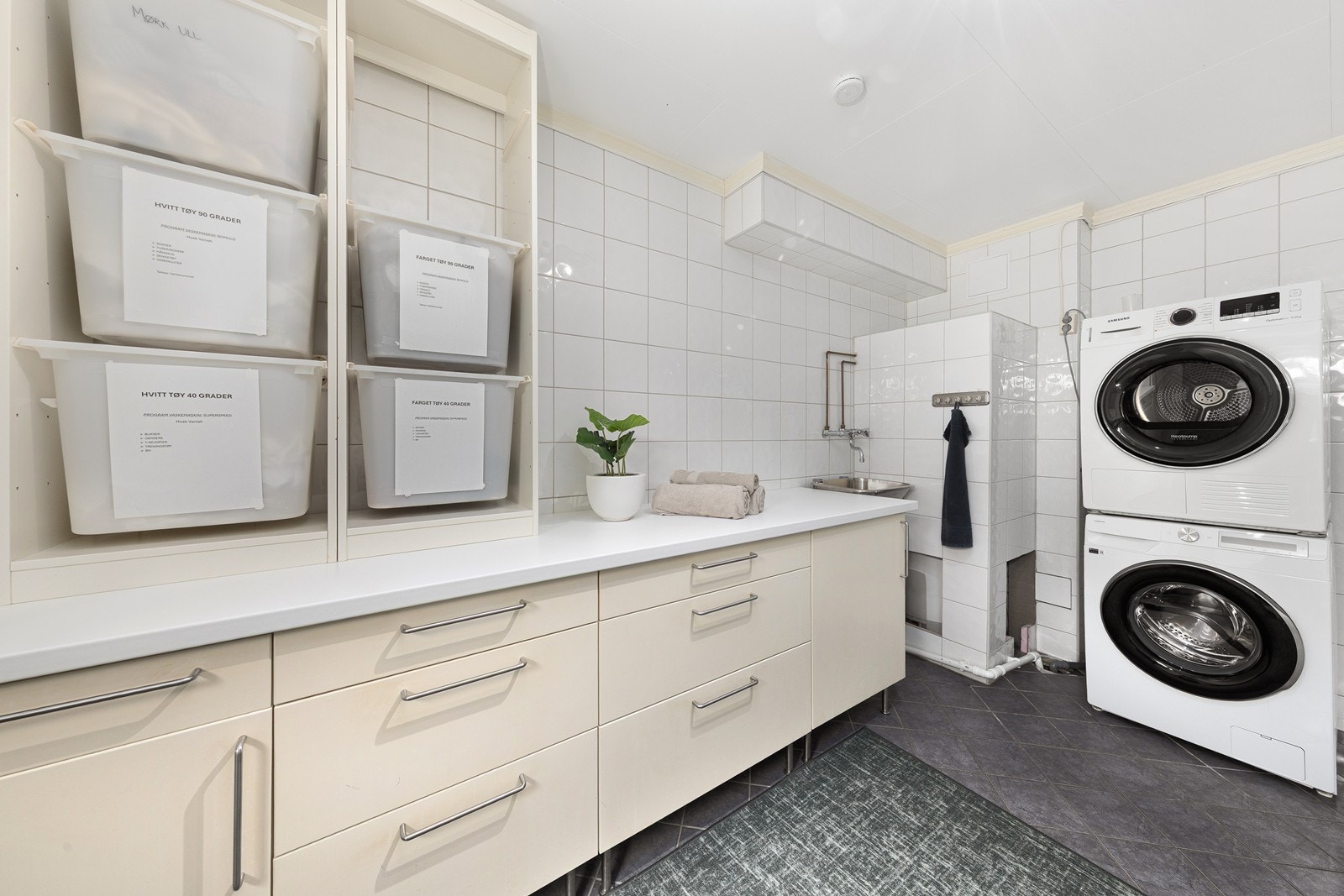 Rommet har flislagt gulv, opplegg for vaskemaskin og rikelig med benke- og oppbevaringsplass. Opplegg for vask og tørk. Galleribilde