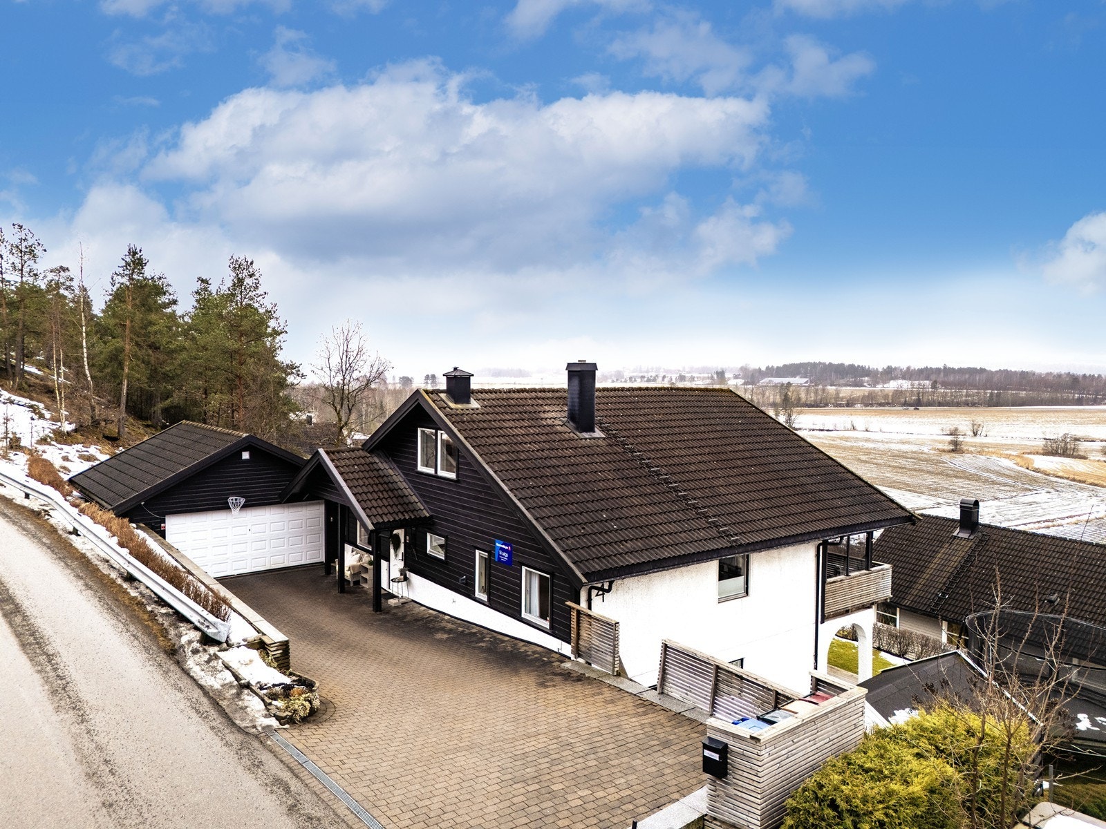 Eiendommen har en forstøtningsmur mot veien, kledd med treverk. Galleribilde