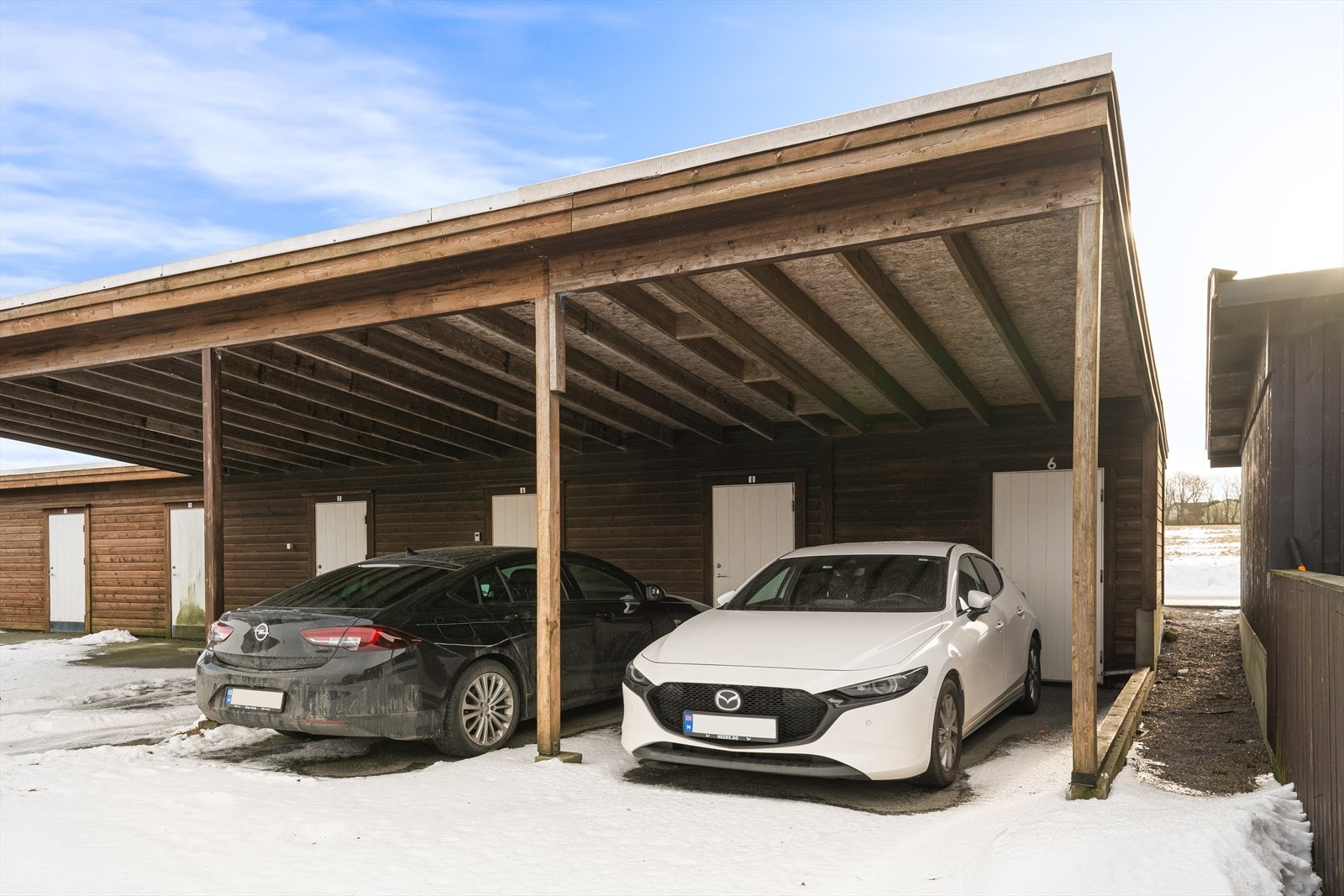 Carport samt sportsbod tilhørende leiligheten i bakkant av carporten. Galleribilde
