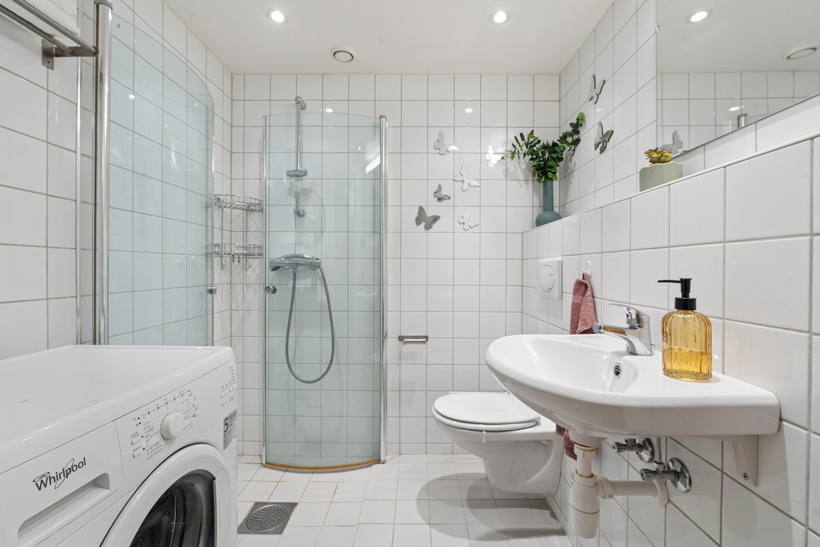 Flsilagt bad med behagelig gulvvarme. Rommet er utstyrt med vegghengt toalett, servant, dusj med glassdører og opplegg for vaskemaskin. Galleribilde