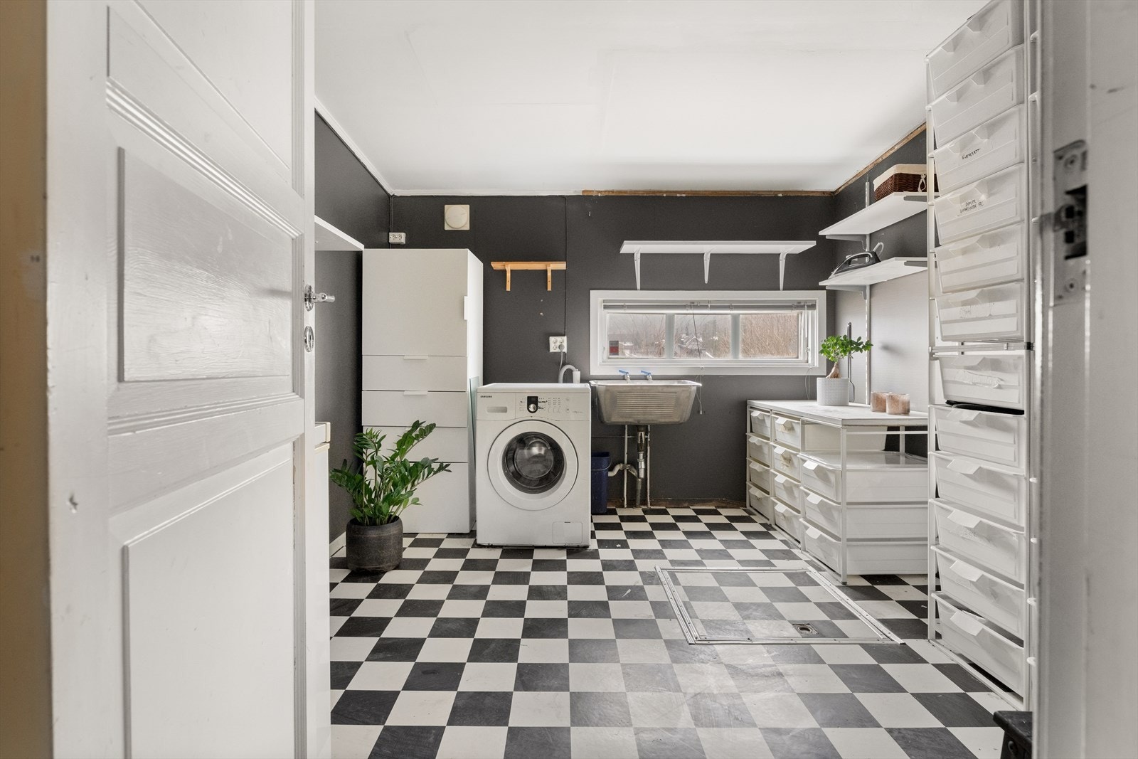 Separat og romslig vaskerom med utslagsvask og opplegg for vaskemaskin. Galleribilde