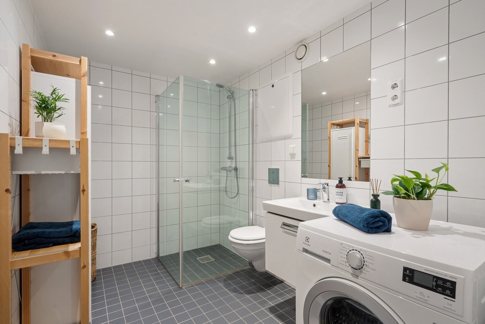 Badet har et tidløst uttrykk med flislagte vegger og gulv, samt gulvvarme som gir ekstra komfort. Rommet har en praktisk og funksjonell utforming med god plass. Galleribilde