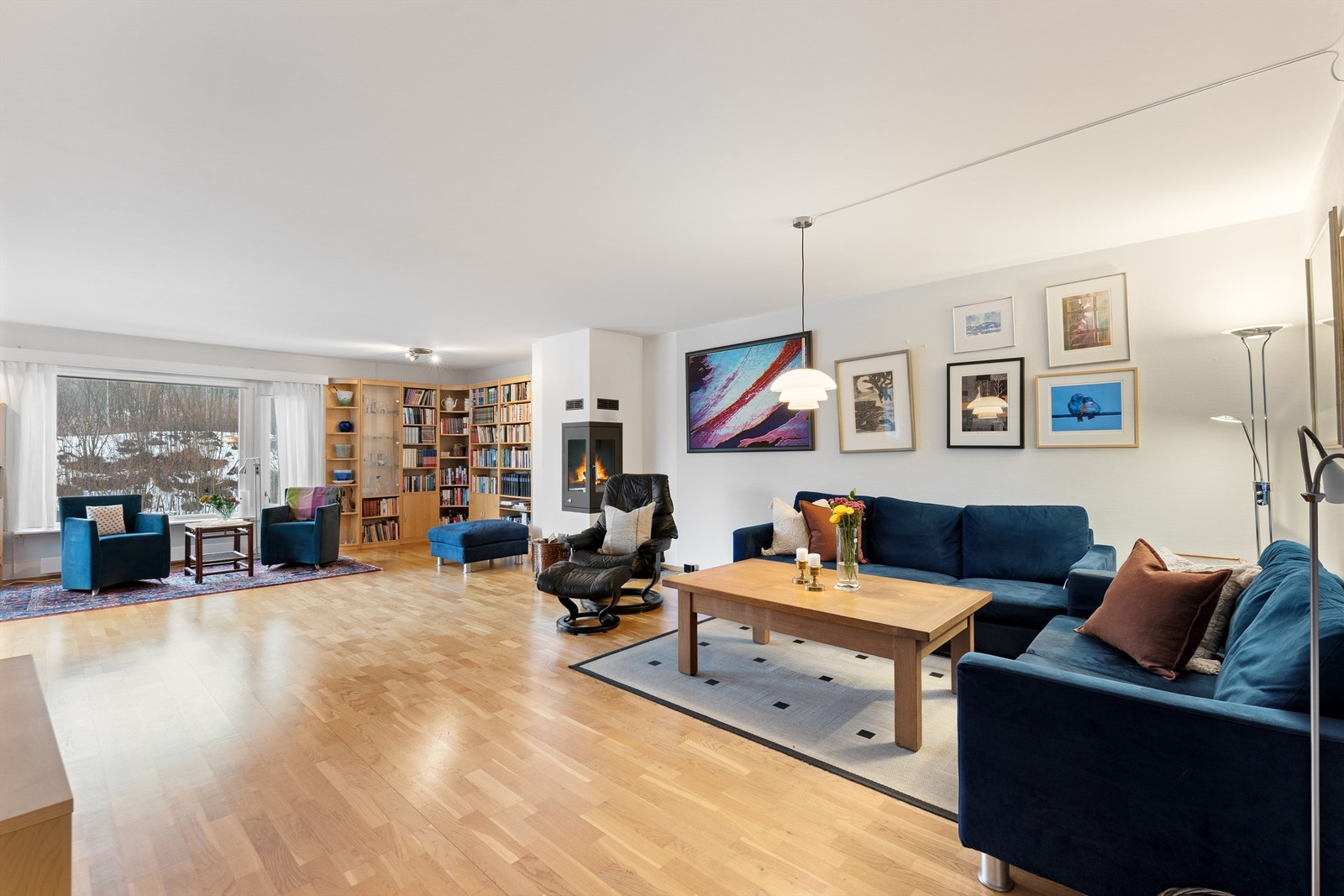Oversiktsbilde som viser stuen i sin helhet, med peis og utgang til terrasse. Galleribilde