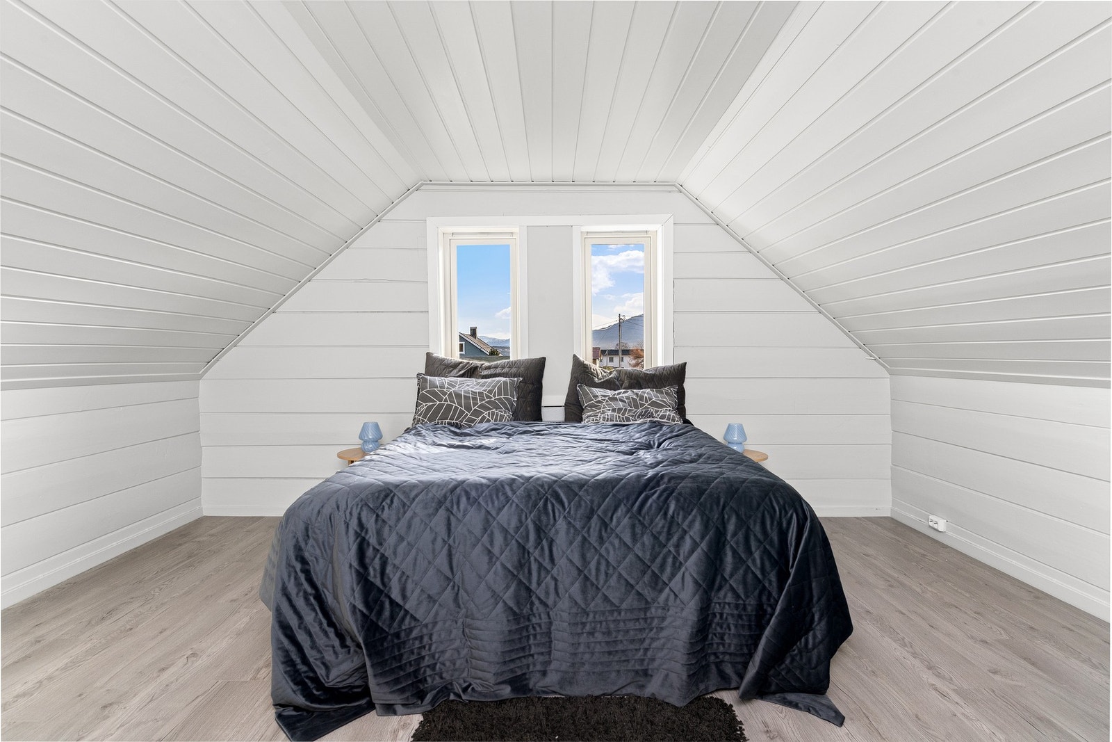 Romslig hovedsoverom med gjennomgående lyse overflater. Galleribilde