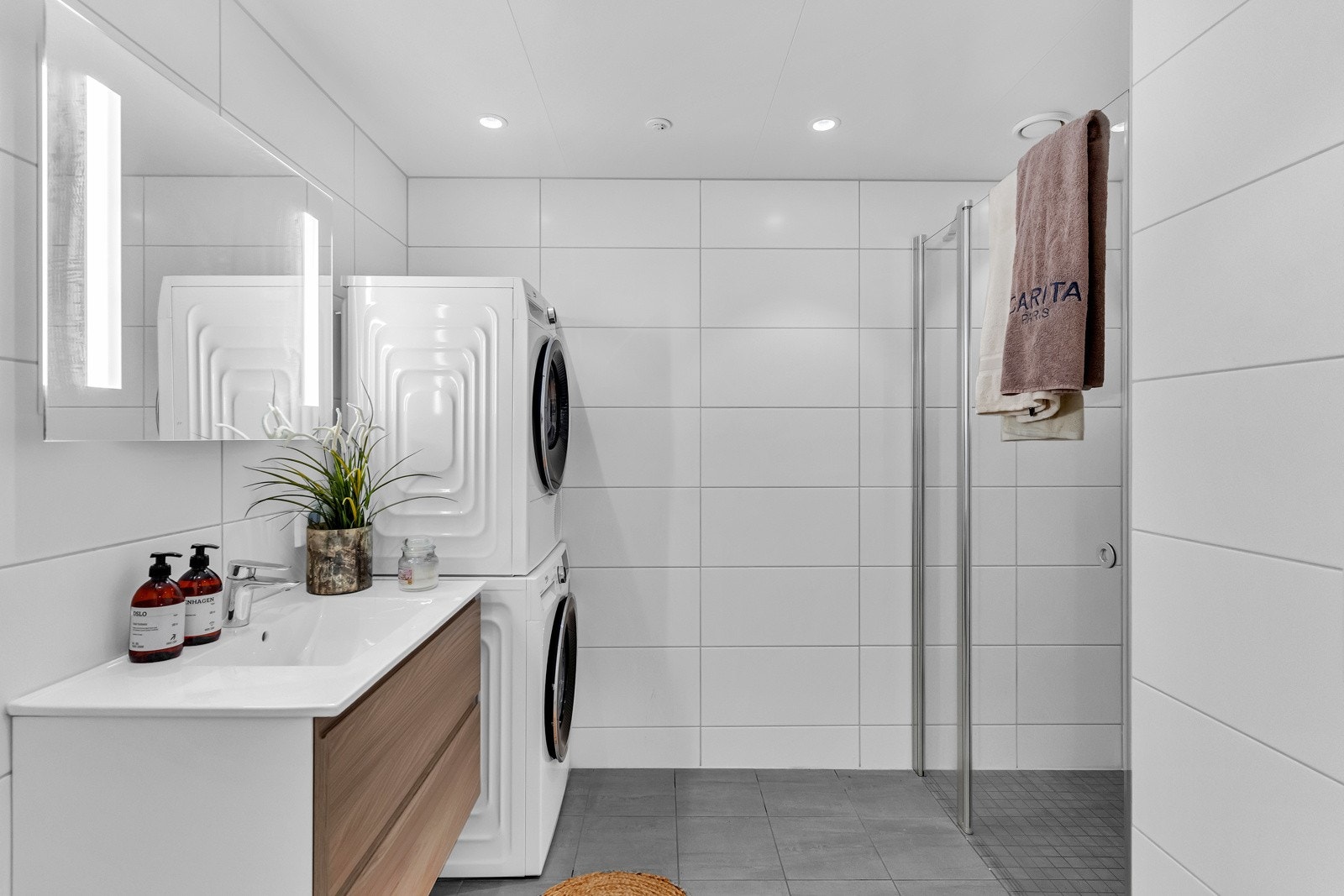 Det er varme i gulvet og downlights i himling. Badet er utstyrt med stor dusjnisje som har fastfelt og dør i herdet glass. Galleribilde