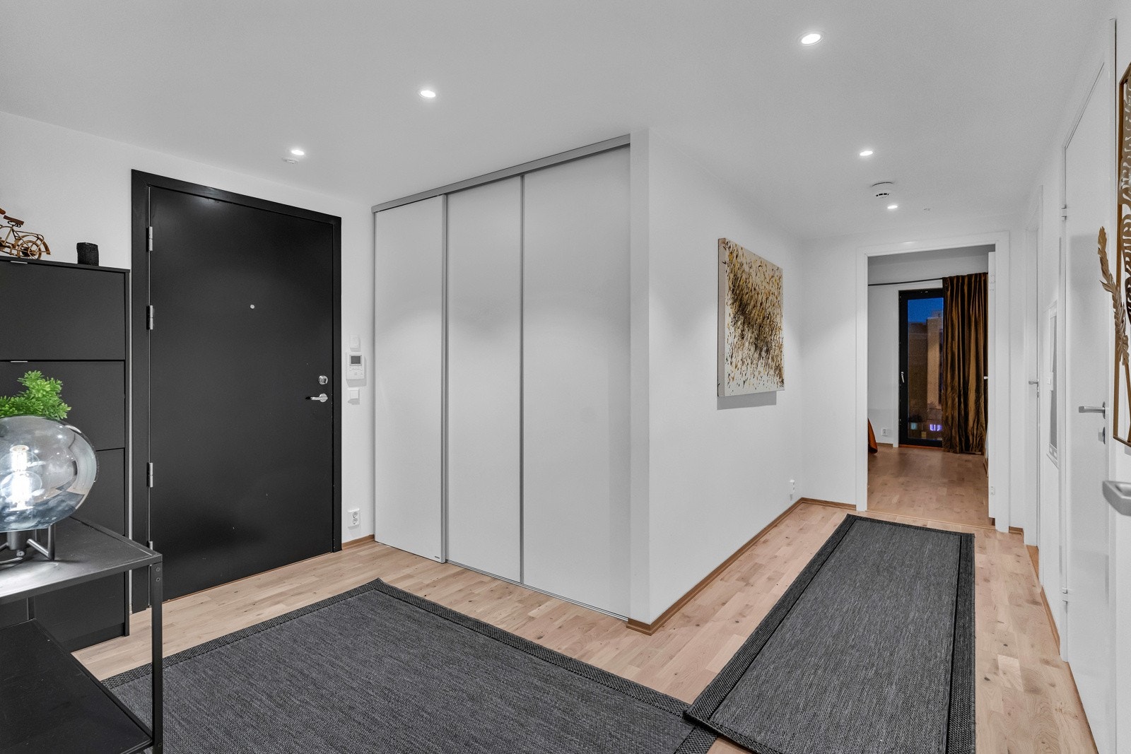 Entreen gir et romslig og godt førsteinntrykk av leiligheten, med lysmalte overflater, downlights i himling og parkett på gulvet. Galleribilde