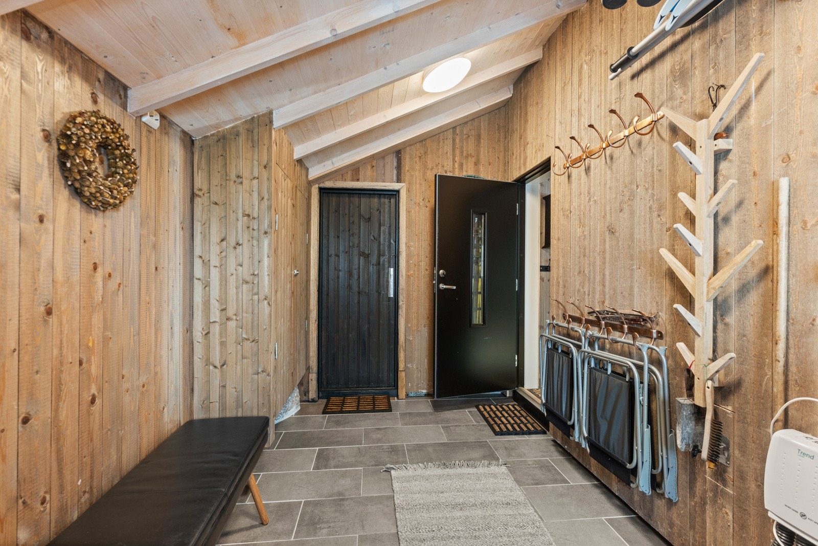 Entrèen har fliser med varmekabler på gulv, panel på vegger og praktiske innebygde skap samt to utganger. Galleribilde