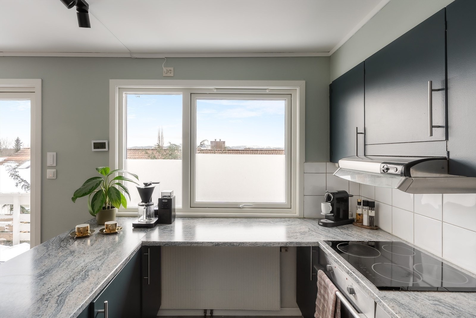 Kjøkkenet har en U-form som frigjør god benke- og skapplass Galleribilde