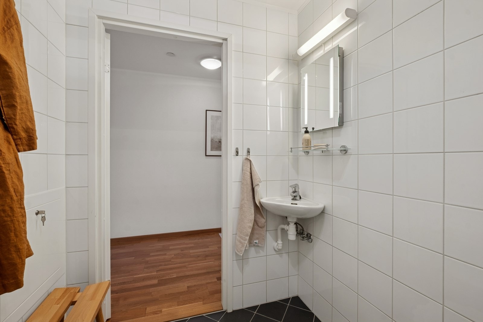 Badet i 1. etasje har en liten servant med ettgreps blandebatteri og speil med integrert belysning. Galleribilde