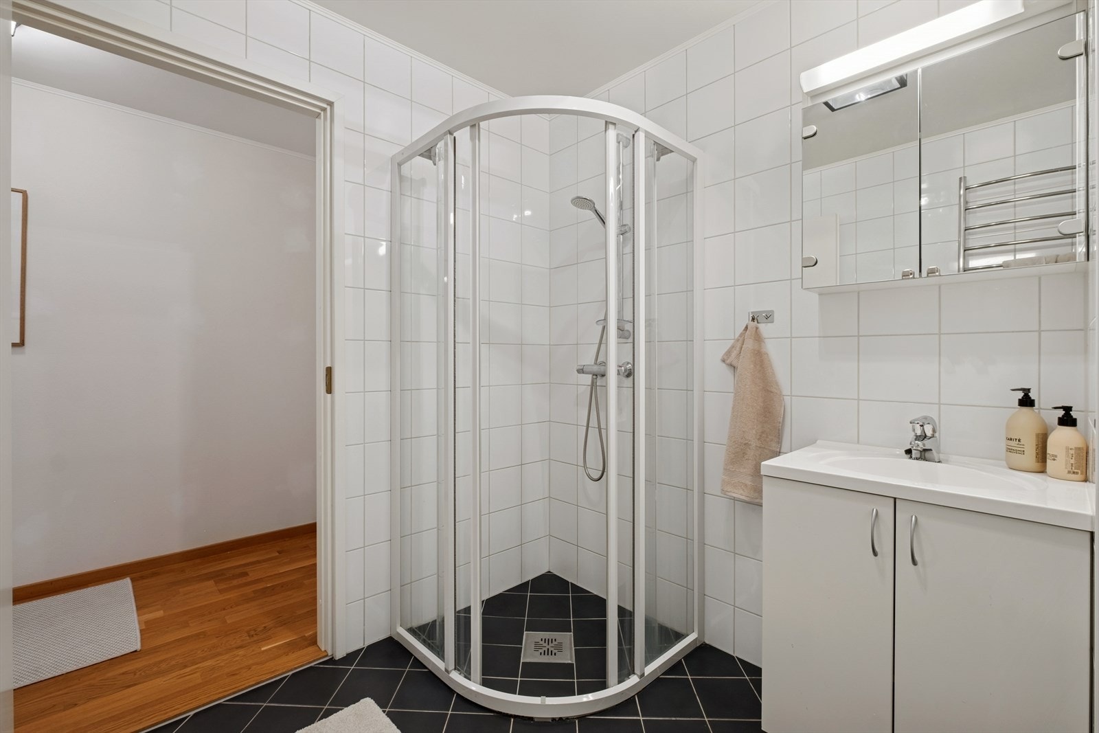 Det er et pent bad i 2. etasje med dusjløsning og servant med underskap. Gulvvarme. Galleribilde